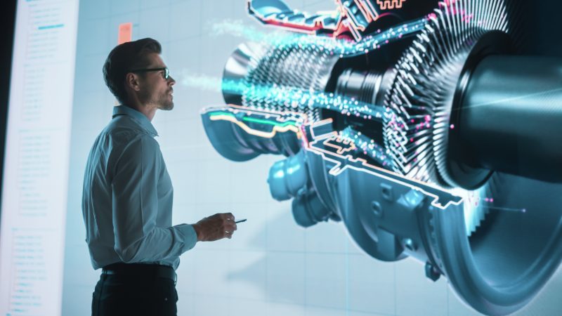 innovative-green-energy-startup-engineer-designing-engine-using-tablet-computer-and-big-wall-screen-to-analyse-prototype-concept-for-sustainable-environmnetally-friendly-carbon-neutral-turbine