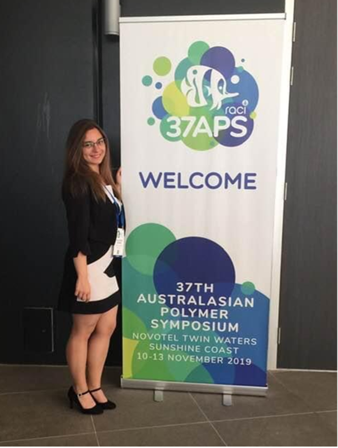 Dr. Valentina Guerra [left] stands next to a pull up banner [right].